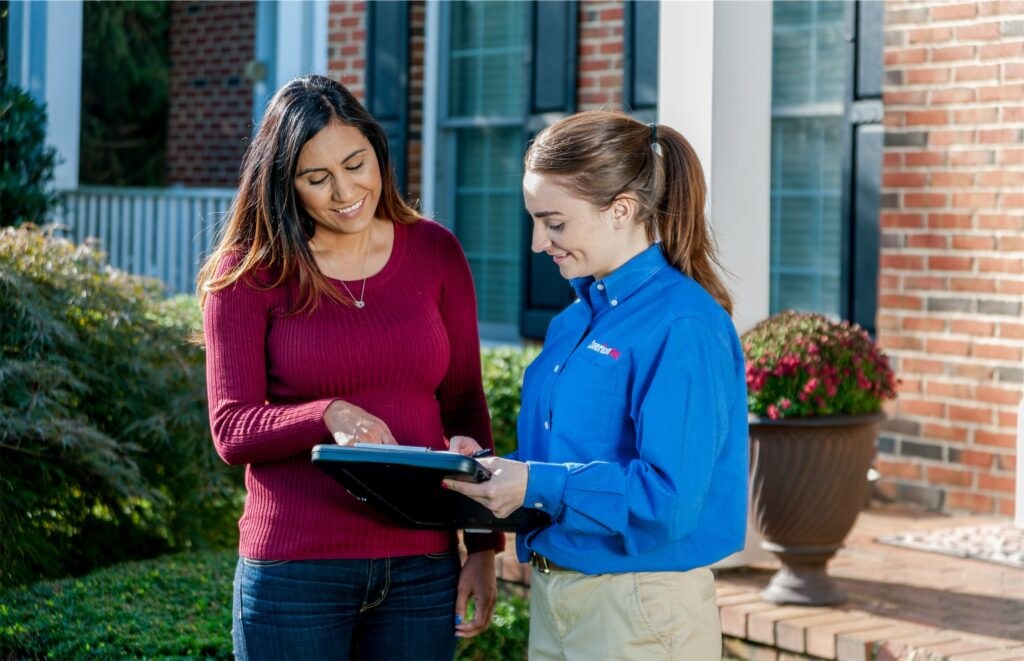 American Pest technicians talking through a home pest control plan with a homeowner