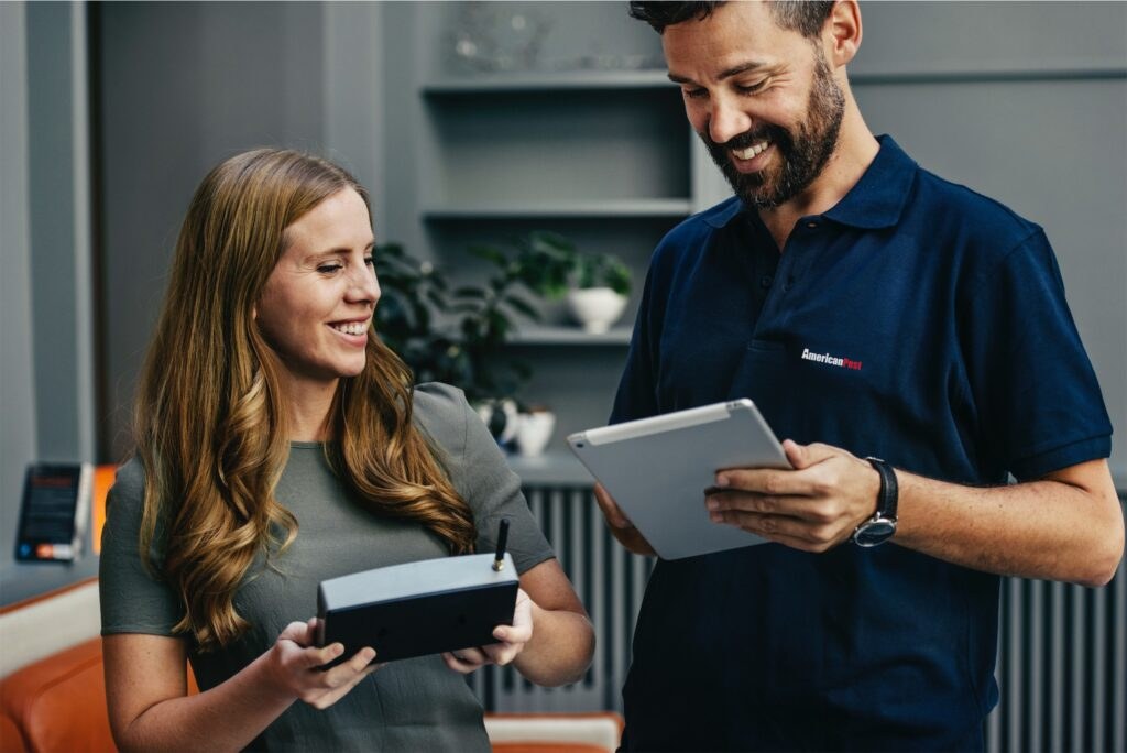 An American Pest technician reviewing a pest control plan with a homeowner